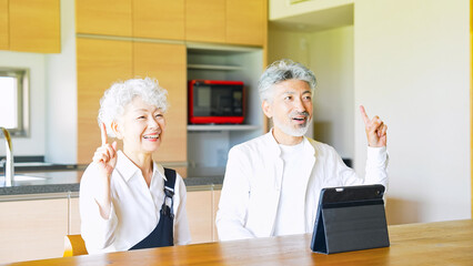 一緒にタブレットを見るシニアカップル