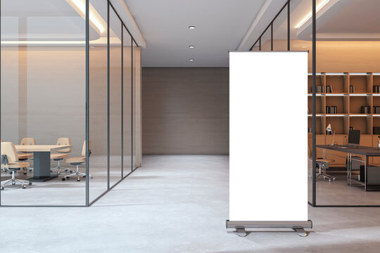 Modern empty corporate office interior with glass walls, desk areas, and a blank roll-up banner mockup stand in the foreground. 3D Rendering