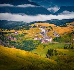 Fantastic morning view of the top of Rolle pass. Wonderful summer scene of Dolomite Alps. Foggy...