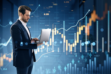 Businessman using laptop analyzing digital financial charts on futuristic virtual interface with forex and stock market data overlayed.