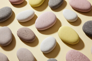 Smooth pastel stone ovals arranged in geometric pattern on beige background, creating calm and modern abstract health focused layout with soft natural textures