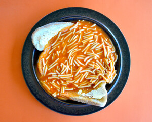  top view of tinned spaghetti on lightly toasted bread with butter.