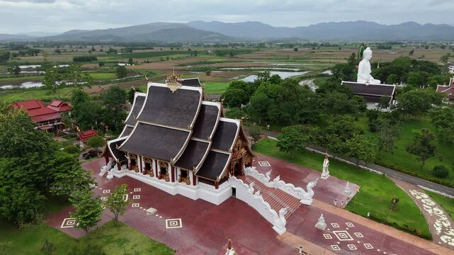 Aerial view of beautiful buildings and white Buddha statue in Wat Wiang Kaew temple in Chiang Saen district in Chiang Rai province of Thailand.