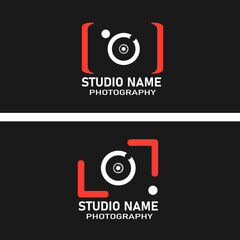 A modern photography studio logo featuring a stylized camera icon with red brackets, a white lens, and a black background. Bold text reads "Photography Studio," expressing a creative .