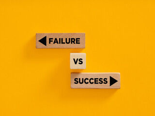 Wooden blocks showing failure vs success choice on yellow background