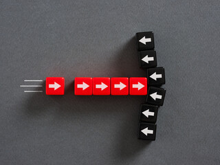 Red and black dice forming arrows diverging on a gray background