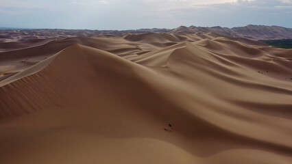 Aerial view of sand dunes in desert at sunset