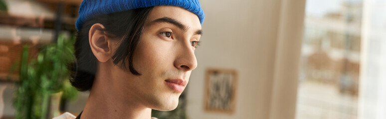 Young man engages in plant care with artistry in a bright studio setting