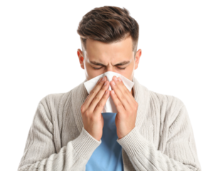 A young man eyes closed in discomfort uses a tissue to blow his nose conveying symptoms of a cold allergy or flu.