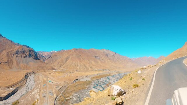 4K shot of scenic view of the Himalayan mountain valley with spiti river flowing in between as seen from road towards Hikkim village in Spiti Valley, Himachal Pradesh, India. Scenic road trip in India