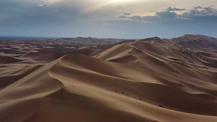 Aerial view of sand dunes in desert at sunset
