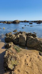 The Gondarem Beach in Foz do Douro, Porto, Portugal. Calm tide over rocky coastline and coarse sand, perfect for resting and relaxing in the summer by the Atlantic shore.