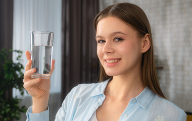 Smiling Woman Holding a Glass of Water Indoors