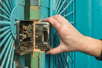 Handyman making door lock repair works, closeup photo. Detailed lock adjustment, ensuring mechanism...