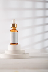 Dropper bottle with blank label, no brand template. Cosmetics mockup jar on concrete decorative stand, white backdrop. Copy space. Beauty product advertising banner
