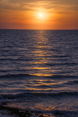 Sunset Over Calm Ocean Waves Reflecting Golden Light in Tranquil Evening
