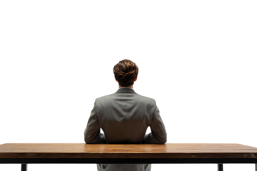 Businessman seated at a desk, viewed from behind.