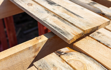 The image shows a close-up view of the wooden beams of a roof structure under construction. The...