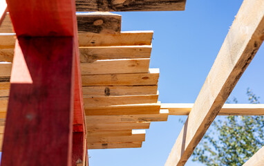 Under-construction residential wooden frame home located near a forest. Commencement of a new...