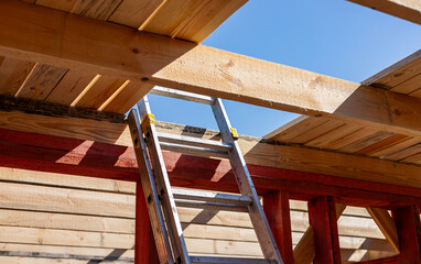 Under-construction residential wooden frame home located near a forest. Commencement of a new...