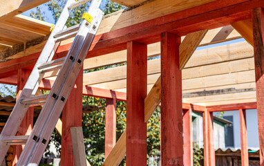 Under-construction residential wooden frame home located near a forest. Commencement of a new...