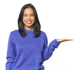 Simple portrait of a young Latina showing a copy space on a palm and holding another hand on waist.