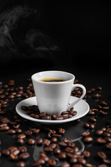 A espresso cup filled with dark coffee surrounded by roasted beans on reflective surface.