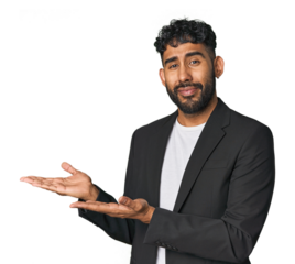 Hispanic businessman in suit in studio holding a copy space on a palm.