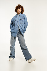 Young woman with curly hair showcases denim fashion on a bright white background