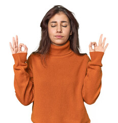 Middle Eastern woman in studio relaxes after hard working day, she is performing yoga.
