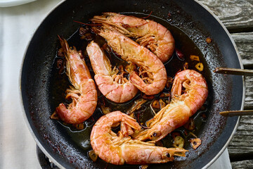 Chef frying red  shrimp with garlic in pan