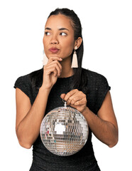 Young Filipina with disco ball looking sideways with doubtful and skeptical expression.
