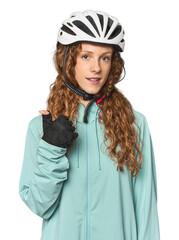 Young redhead cycling in studio smiling and raising thumb up