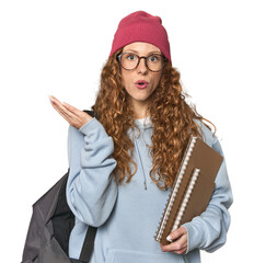 Redhead caucasian young woman student with books surprised and shocked.