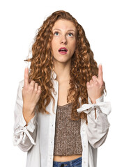 Simple redhead studio portrait pointing upside with opened mouth.
