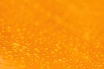 Raindrops on smooth yellow metallic industrial object surface, weather and climate concept