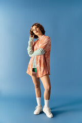 Summer vibes: a stylish young woman in a vibrant outfit against a blue backdrop