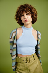 Young woman showcases trendy summer fashion against vibrant green backdrop