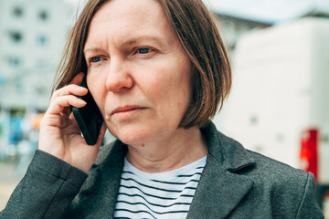 Businesswoman talking on smartphone on downtown city street