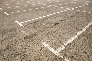 Empty parking lots with asphalt flooring and white marking lines