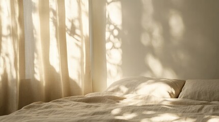 Sunlight streams through sheer curtains onto a bed with linen bedding.
