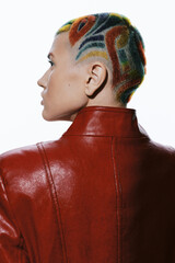 Woman with colorful geometric shaved hairstyle in red leather jacket, side profile view, artistic...