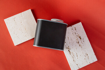 Black can for packaging with stylish props on red background.