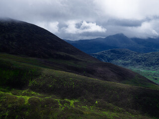 Overcast day at Coomloughra Horseshoe viewing green mountains and cloudy skies over County Kerry,...