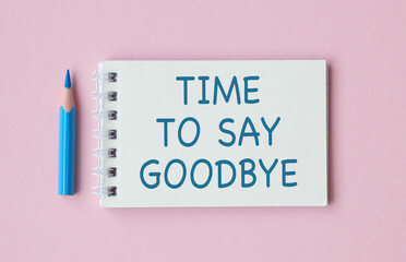 A blue pencil is on a white notebook with the words Time to Say Goodbye writte