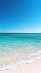 Obraz premium Pristine tropical beach with turquoise water and clear blue sky, gentle waves washing over soft white sand in a tranquil seascape, captured in bright daylight.
