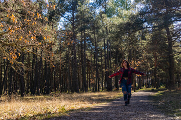 Obraz premium Young woman walking in forest feeling freedom and happiness during hiking in nature