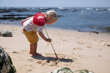 4-year-old European girl searching for seashells on the beach