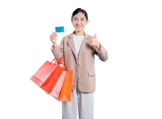 A happy young Asian woman gives a thumbs-up while holding shopping bags and a credit card, signifying approval and satisfaction with using the card for her purchases.
