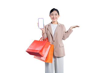 young Asian woman holding shopping bags points to a credit card with her other hand, recommending it as a secure and convenient payment method for shopping, isolated on a png 